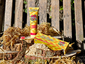 Dr. Bauer’s Zahnpasta Caribic Dream mit Maracuja-Geschmack auf Holz und Stroh inszeniert, inklusive nachhaltiger Zahnbürste.