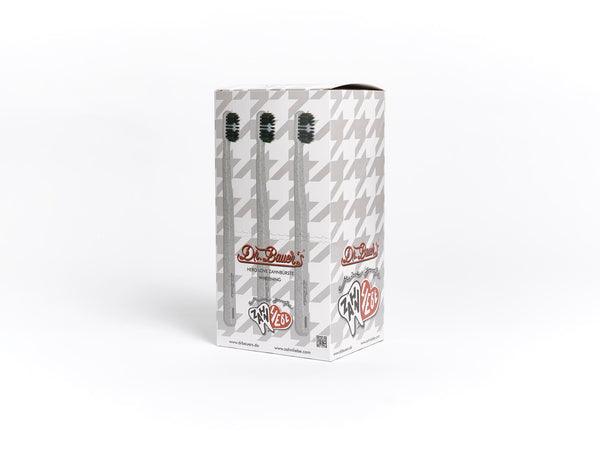 Eine Schachtel Dr. Bauers Hero Love Whitening Zahnbürste mit Supersoftborsten, mit Hahnentrittmuster auf weißem Hintergrund.