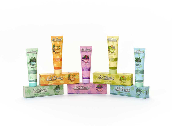 Fünf farbenfrohe Dr. Bauer's Zahnpasta Fruits of Love Probier-Set Tuben und Boxen (5x90ml) sind halbkreisförmig auf weißem Untergrund angeordnet.