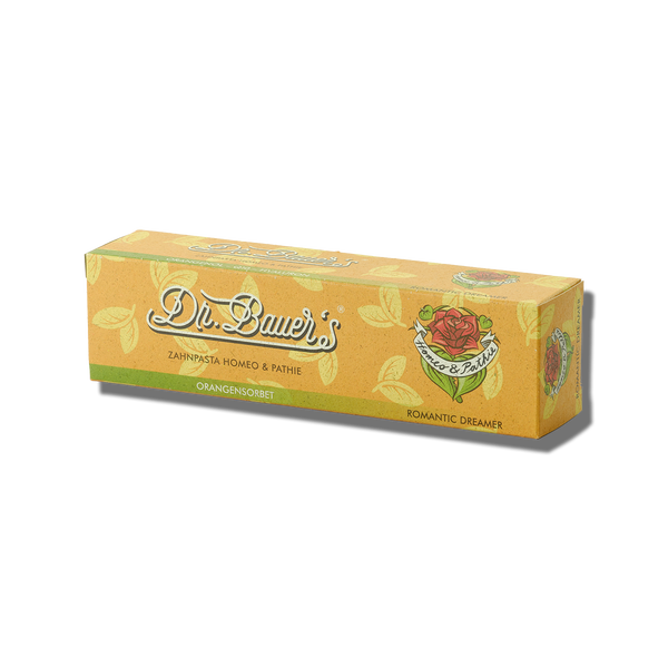 Die orangefarbene Schachtel der Dr. Bauer's Homöopathie Zahnpasta Romantic Dreamer 90 ml ist mit einem Rosendesign versehen – ideal für den Romantic Dreamer, der sich eine sanfte, pflanzliche Zahnpasta von Dr. Bauer's wünscht.