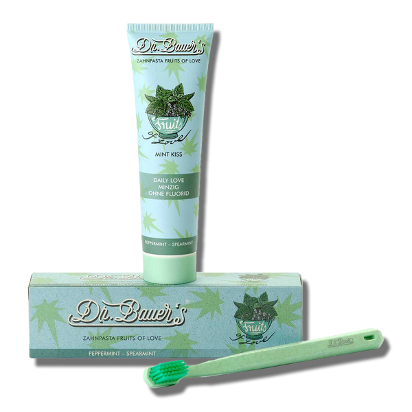Dr. Bauer's Zahnpasta Fruits of Love Mint Kiss 90ml, passende Bürste und Blätter-Box sorgen für natürliche Frische – alles von Dr. Bauer's auf weißem Hintergrund.