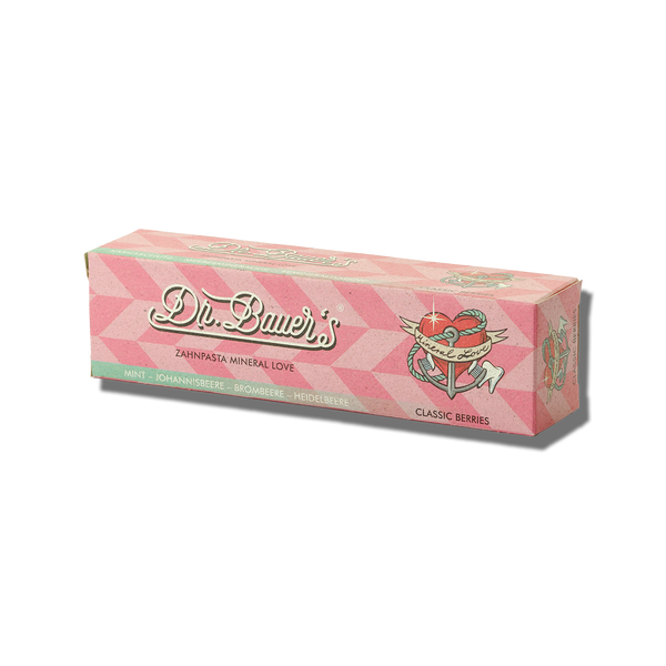 Dr. Bauers Zahnpasta Mineral Love Classic Berries 90 ml kommt in einer rosafarbenen Schachtel mit einer Herz- und Flügelillustration; angereichert mit Meeresmineralien für empfindliche Zähne.