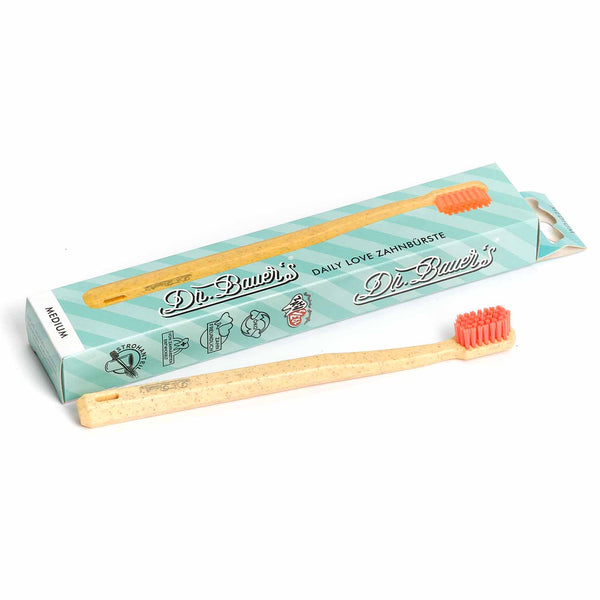 Die Dr. Bauer's Daily Love Zahnbürste medium von Dr. Bauer's überzeugt mit Holzgriff, roten biobasierten Borsten und türkisfarbener Box - die nachhaltige Wahl für umweltbewusste Zahnpflege.