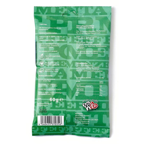 Rückseite einer grünen Dr. Bauer's Xylinetten Pfefferminz 60g Packung mit deutschem Text über Zahnpflege und Karies vorbeugen, Nährwertangaben, Strichcode und Dr. Bauer's Logo sichtbar.