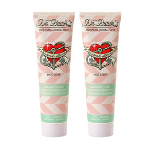 Dr. Bauer's Zahnpasta Mineral Love Hot Love 90ml 2er Pack: Zwei Tuben mit rosa geometrischem Design und Herz-Tattoo - perfekt für ein sinnliches Zahnputzerlebnis.