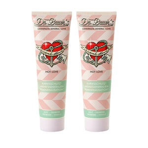 Dr. Bauer's Zahnpasta Mineral Love Hot Love 90ml 2er Pack: Zwei Tuben mit rosa geometrischem Design und Herz-Tattoo - perfekt für ein sinnliches Zahnputzerlebnis.
