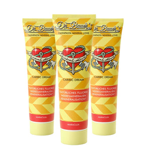 Das Dr. Bauer's Zahnpasta Mineral Love Caribic Dream 90ml 3er Pack enthält drei gelbe Tuben mit einem Herz- und Ankerlogo - ideal für empfindliche Zähne, angereichert mit Meeresmineralien.