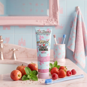 Dr. Bauer's Zahnpasta Lovely Friends Prinzessin 90ml steht auf einem pastellfarbenen Badezimmertisch mit Äpfeln, Erdbeeren, Minze und einer Zahnbürste - moderne Details, die durch die schlichte Schrift Helvetica Neue hervorgehoben werden und für einen frischen, stilvollen Look sorgen.