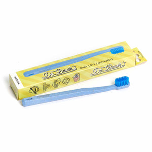 Vor der gelben Dr. Bauer's Verpackung steht die blaue Dr. Bauer's Daily Love Zahnbürste medium - nachhaltig, mit biobasierten Borsten, für stilvolle und bewusste Zahnpflege.