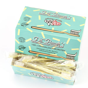 Schachtel mit 100 Dr. Bauer's Einmalzahnbürsten -STROH- in gelb, jeweils mit integrierter Zahnpasta und einzeln verpackt in biologisch abbaubarer Verpackung; mit Zahngrafik auf türkisfarbener Schachtel.