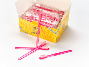 Abgebildet ist eine gelbe Schachtel Dr. Bauer's Einmalzahnbürsten mit Zahnpasta 100er Packung PINK, in der sich mehrere pinkfarbene Zahnbürsten befinden und drei davor auf einer weißen Fläche liegen.