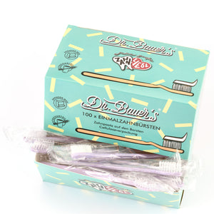 Schachtel Dr. Bauer's Einmalzahnbürsten -STROH- 100er Violett mit einzeln verpackten lila Zahnbürsten oben drauf.