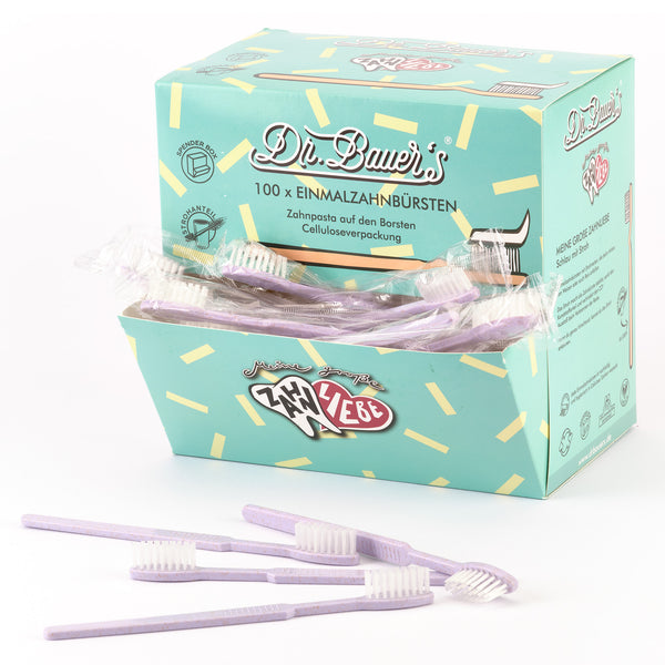 Schachtel von Dr. Bauer's Einmalzahnbürsten -STROH- 100er Violett mit mehreren lila Einwegzahnbürsten mit integrierter Zahnpasta, vorne ausgestellt.