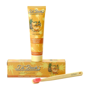 Dr. Bauer's Zahnpasta Fruits of Love Fruit Splash 90ml, im Karton, und einer Bambuszahnbürste mit rosa Borsten auf weißem Untergrund – für sanftes Putzen mit exotischen Fruchtaromen.