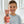 Ein lächelnder Junge im gestreiften Hemd hält den Zahnpasta Lovely Friends Teddy 90ml von Dr. Bauer in einem modernen Badezimmer mit Webdesign-Elementen, die von Helvetica Neue inspiriert sind.