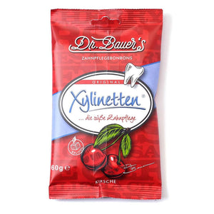 Dr. Bauer's Xylinetten Kirsche 60g: Zahnpflegebonbons mit Kirschgeschmack in roter Verpackung, mit Kirschen und Zahngrafik für Zahngesundheit und puren Kirschgenuss.