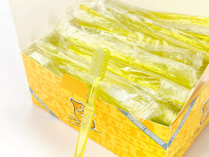 Eine Schachtel Dr. Bauer's Einmalzahnbürsten mit Zahnpasta 100er Packung GELB, davor eine gelbe Einwegzahnbürste von Dr. Bauer's.