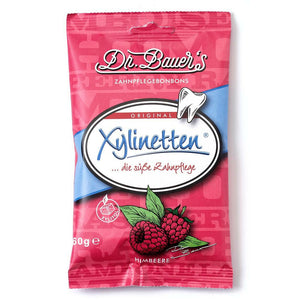 Eine rote Tüte Dr. Bauer's Xylinetten Himbeere 60g Zahnpflege Bonbons mit Himbeerillustrationen.